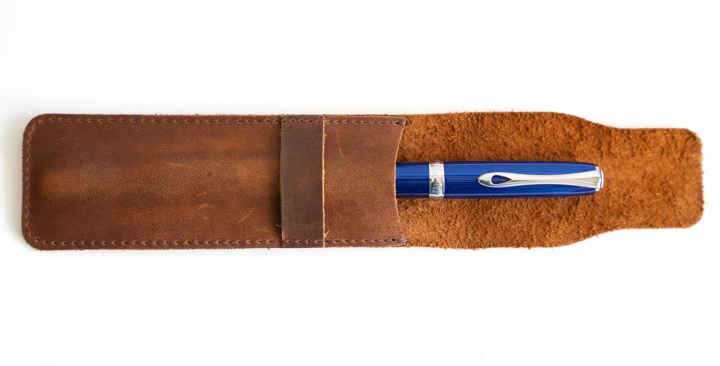 Daimay leather pen case, open with a blue pen inside